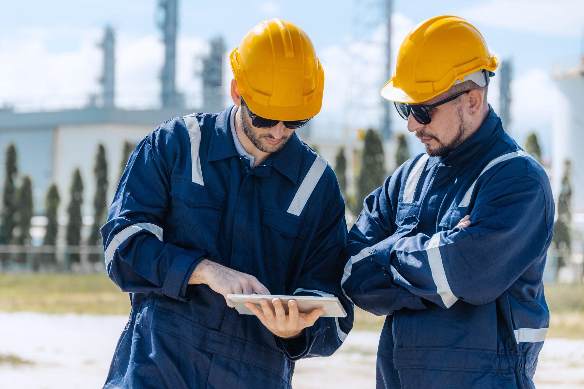 Engineer teamwork, professional male workers working survey inspection at petroleum refinery outdoor