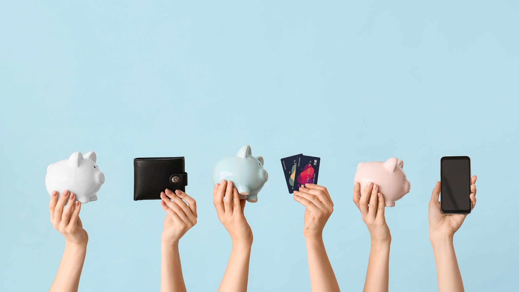 Female hands with piggy banks, credit cards, wallet and mobile p
