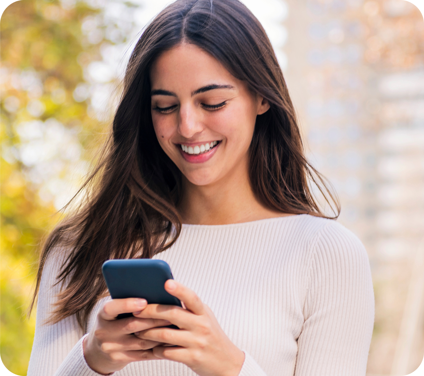 A customer smiling at her phone beside a My Rewards balance