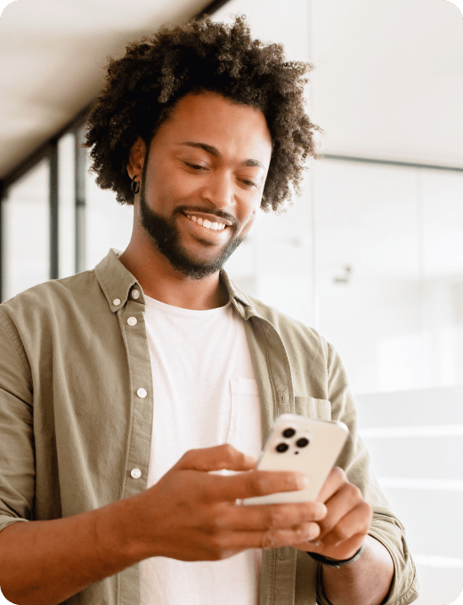 A man smiling at his phone
