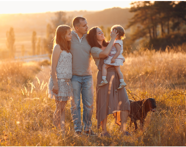 A family standing together in a sunlit field